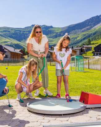 Una famiglia gioca a minigolf nel soleggiato paesino di montagna di Malbun, nel Liechtenstein