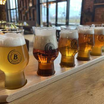 Diversi tipi di birra in un set di degustazione su un tavolo di legno - dalla birra chiara a quella scura, servite in eleganti bicchieri nella Liechtensteiner Braustube
