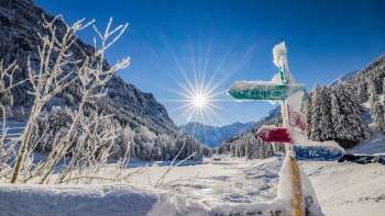 Cartello innevato nell'area di sci di fondo della Valüna - Steg con il sole d'inverno