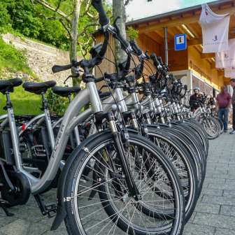 Una fila di moderne e-bike davanti al Liechtenstein Centre di Vaduz - punto di partenza per tour di esplorazione sostenibile nel Principato