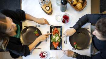 Una coppia gusta un antipasto a base di pomodori e mozzarella