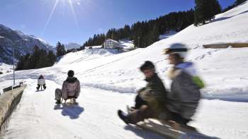 Insegnanti sulla pista da slittino in una bella giornata di sole nel paesaggio invernale