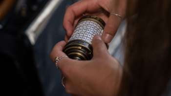 Due donne con iPad risolvono enigmi nella Sala Avventura all'aperto di Malbun, in un ambiente alpino