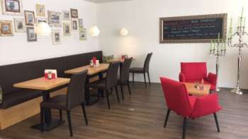  Accogliente caffetteria con posti a sedere moderni, parete di quadri decorativi e caldo pavimento in legno