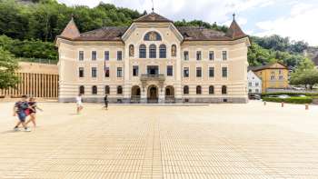Edificio governativo di Vaduz con facciata chiara e piazza antistante.