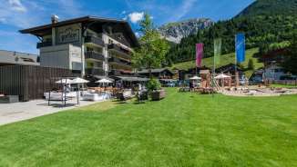 Hotel Gorfion a Malbun, adatto alle famiglie, con un'ampia area giochi e lo sfondo delle montagne in estate