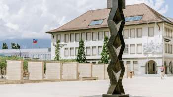 Scultura The Prayer di Heinz Mack sulla Peter-Kaiser-Platz di Vaduz - forma astratta e verticale in metallo scuro.