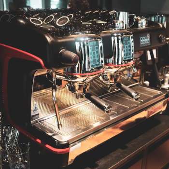 Macchina da caffè nel ristorante con superficie in acciaio inox lucido e accenti rossi