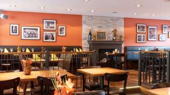 Accogliente sala da pranzo del ristorante New Castle con colori caldi, caminetto ed eleganti tavoli in legno per un'esperienza culinaria rilassata nel Liechtenstein. Accogliente sala da pranzo del ristorante New Castle con colori caldi, caminetto ed eleganti tavoli in legno per un'esperienza culinaria rilassata nel Liechtenstein.