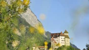 La Rocca di Gutenberg troneggia di fronte a un massiccio roccioso, incorniciato dal verde della natura e dalla luce estiva.