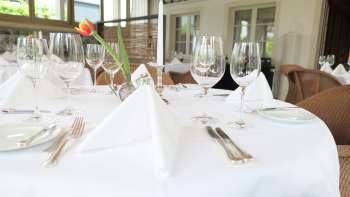 Tavola elegantemente apparecchiata nel ristorante Vivid con eleganti decorazioni per la tavola in un'atmosfera luminosa