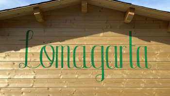 Vista del logo verde Lömagarta, elegantemente impresso sulla facciata in legno dell'accogliente birreria.
