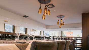 Moderna area ristorante con vista sulla facciata della finestra ed eleganti lampade a sospensione.