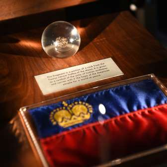 Mostra nel Tesoro del Liechtenstein: bandiera del Liechtenstein con corona d'oro e globo di vetro con manufatto storico