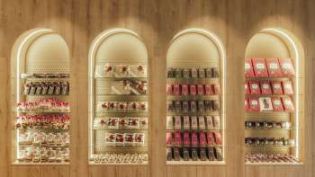 Scaffale decorativo a parete con scatole di cioccolatini e dolciumi disposti in modo elegante