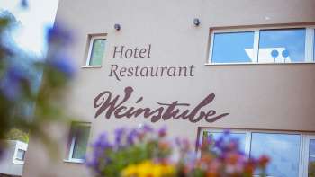 Vista del ristorante Weinstube con fiori in primo piano 