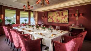 Tavola apparecchiata con porcellane pregiate, bicchieri e tovaglioli sotto la luce naturale