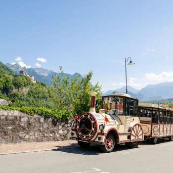 Il treno reale attraversa la soleggiata Vaduz con la vista del castello sullo sfondo.