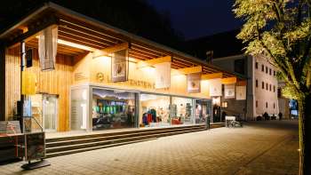 Il moderno centro visitatori con facciata in vetro di Vaduz di notte, illuminato in modo invitante