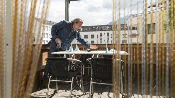Accogliente terrazza del ristorante Made in Italy con schermo protettivo e vista sulla città.