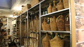 Scaffali con utensili tradizionali, damigiane e oggetti di uso quotidiano