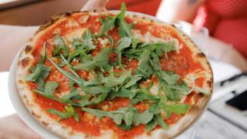 Insalata caprese con pomodori, mozzarella, basilico e condimento balsamico, accompagnata da pane fresco