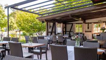 Invitante area esterna con interni rustici in legno, tavoli decorati e fiori in fiore