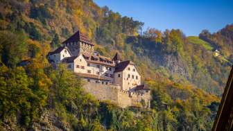 Il castello di Vaduz nel Liechtenstein, circondato da alberi dai colori autunnali e da un cielo soleggiato