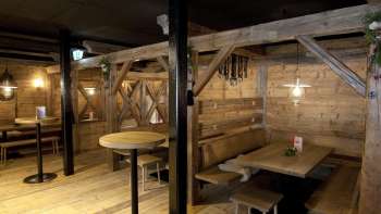 Accogliente area salotto con panche e tavoli in legno nel tradizionale stile Malbuner Lädeli