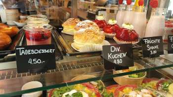 Variegata selezione di torte, crostate e snack freschi nella vetrina del Café 44 Café im Hof