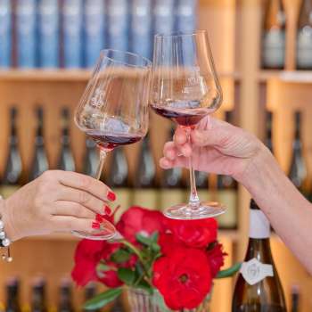 Due persone brindano con bicchieri di vino rosso durante una degustazione nella Hofkellerei Vaduz