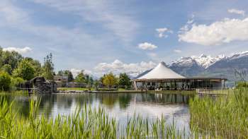Moderno padiglione sull'acqua nell'Impianto ricreativo di Grossabünt in Liechtenstein, circondato dalla natura e con vista sulle Alpi.