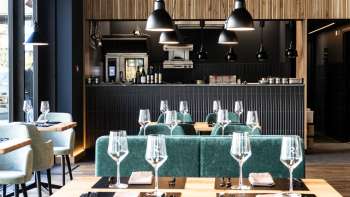 Accogliente sala da pranzo con disposizione rilassata dei posti a sedere, arredi moderni e pareti dal design creativo