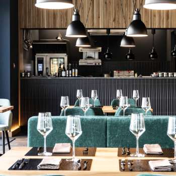 Accogliente sala da pranzo con disposizione rilassata dei posti a sedere, arredi moderni e pareti dal design creativo