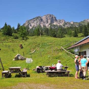 Vista sulle montagne dall'Alpe Guschg, dove alcune persone fanno una pausa e si godono il panorama