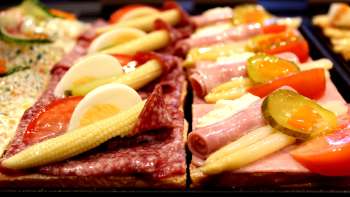 Panini con salsiccia, formaggio, uova e verdure nella vetrina della pasticceria Balu