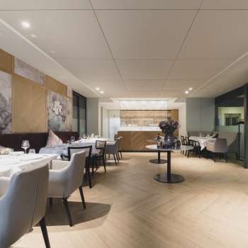 Ampia zona pranzo con un'atmosfera elegante, grandi tavoli e sedute moderne