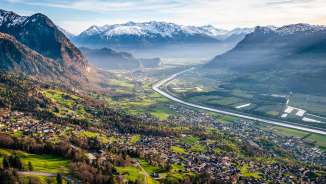 Una vista mozzafiato dalla collina sulla valle del Reno con campi, villaggi e montagne innevate: un idillio naturale nel Liechtenstein.