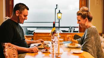 Coppia che si gode una cena intima a lume di candela con vista sull'area esterna