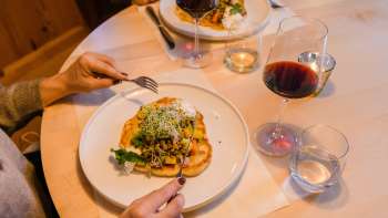 Primo piano di un piatto principale elegantemente preparato con vino rosso al Gasthof Au.