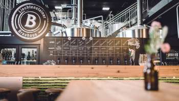 Vista dell'elegante sistema di erogazione e dell'area della birreria con serbatoi in acciaio inox e design industriale.