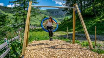 Una donna dondola tra le montagne del Liechtenstein e si gode il panorama