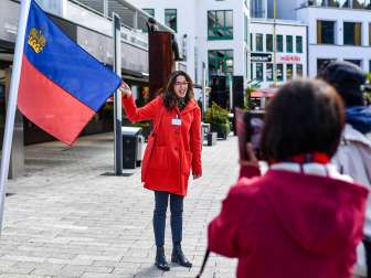 La guida cittadina presenta la bandiera del Liechtenstein durante una visita guidata nel centro di Vaduz