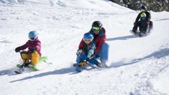 Divertimento in famiglia sulla pista da slittino innevata di Malbun: bambini e adulti si godono la discesa nel paradiso invernale del Liechtenstein.