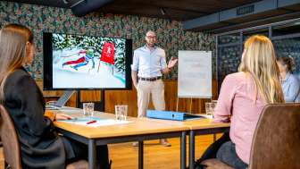 Moderna sala conferenze con partecipanti a una riunione di lavoro, presentazione sullo sci nel Liechtenstein sullo schermo