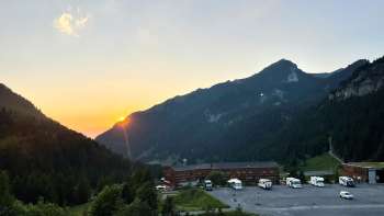 Diversi camper sono parcheggiati nell'area di sosta di Malbun, con il panorama montano sullo sfondo