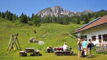 Vista sulle montagne dall'Alpe Guschg, dove alcune persone fanno una pausa e si godono il panorama