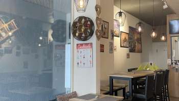 Sala da pranzo elegantemente arredata con mobili in legno nero, pavimenti in legno e decorazioni creative alle pareti