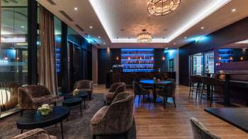 Bar accogliente con illuminazione elegante e una selezione di alcolici.