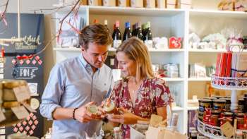 Una coppia scopre le specialità regionali nel Hoi-Laden di Vaduz: scoprite da vicino i prodotti autentici del Liechtenstein.